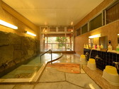 伊豆石に掛け流しの湯が溢れる「男性用大浴場」