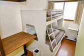 セミダブルサイズの二段ベッドが配置された、広さ4.5畳ほどの個室です。