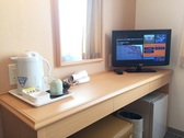 [HOTEL AZ 鹿児島大崎店] 客室デスク（電気ポット、湯飲み、コップ、お茶、ドライヤー、テレビ）